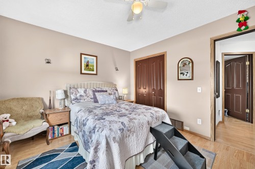 Light wood-finish flooring, built-in dual door closet, ceiling fan, and painted walls - 13069 37 Street Nw, Edmonton, AB - Indoor Photo Showing Bedroom