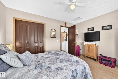 Wood-finish flooring with neutral wall paint and a ceiling fan - 13069 37 Street Nw, Edmonton, AB - Indoor Photo Showing Bedroom