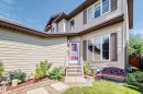 Two-story exterior with light-toned horizontal siding, brown trim, and a white front entry door with a storm door - 13069 37 Street Nw, Edmonton, AB  - Outdoor 