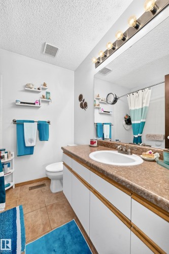 Vanity with integrated sink, chrome faucet, and expansive wall-mounted mirror - 13069 37 Street Nw, Edmonton, AB - Indoor Photo Showing Bathroom