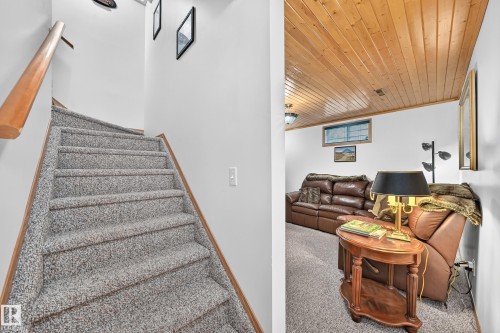 Staircase with carpeted treads and wood handrail - 13069 37 Street Nw, Edmonton, AB - Indoor Photo Showing Other Room