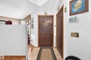 Entryway featuring a paneled door, tiled flooring, wood-finish flooring, and white walls - 13069 37 Street Nw, Edmonton, AB  - Indoor Photo Showing Other Room 