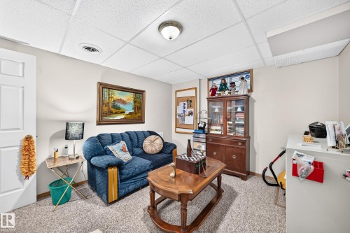 Recessed ceiling lighting with a textured ceiling, a built-in window, and a paneled white door - 13069 37 Street Nw, Edmonton, AB - Indoor Photo Showing Living Room