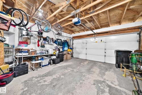 Concrete flooring, exposed ceiling joists, overhead lighting, and a white panel garage door - 13069 37 Street Nw, Edmonton, AB - Indoor Photo Showing Garage