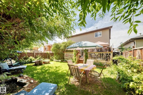Expansive backyard featuring a manicured lawn, established garden beds, and a wood-decked patio with spindle railings - 13069 37 Street Nw, Edmonton, AB - Outdoor With Deck Patio Veranda