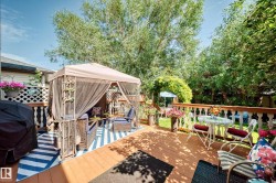 Expansive wood deck with turned baluster railing, privacy lattice, and mature tree canopy - 