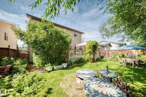 Expansive backyard featuring a green lawn, mature trees, wood fencing, and a raised wood deck - 13069 37 Street Nw, Edmonton, AB - Outdoor