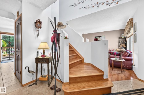 Wood-finish staircase, tile flooring, wood-finish flooring, and a multi-pane glass door - 13069 37 Street Nw, Edmonton, AB - Indoor Photo Showing Other Room