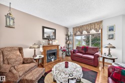 Recessed fireplace with a wood mantel, hardwood flooring, and large picture windows - 