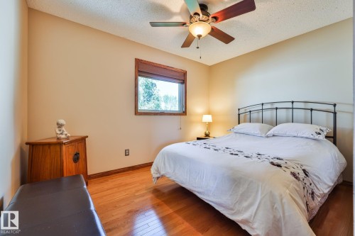 Bedroom 2 offers hardwood flooring and a ceiling fan with integrated lighting - 3764 30 Street Nw, Edmonton, AB - Indoor Photo Showing Bedroom