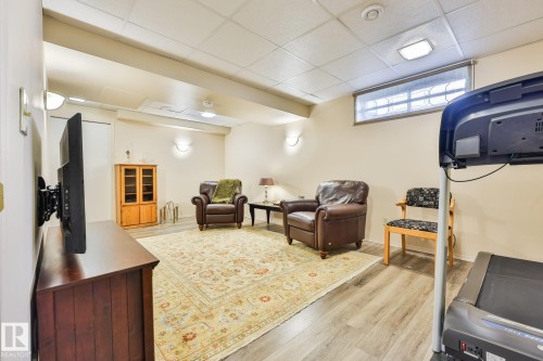 This huge lower level family room features newer plank vinyl flooring - 3764 30 Street Nw, Edmonton, AB - Indoor