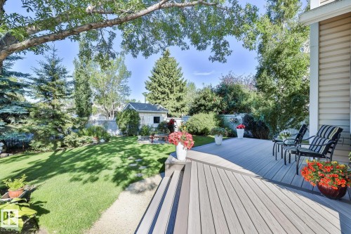 Spectacular fenced backyard with a massive newer 2-tier composite deck, stone stepping path, fire pit area, huge storage shed and loads of mature trees, shrubs & flower beds - 3764 30 Street Nw, Edmonton, AB - Outdoor With Deck Patio Veranda