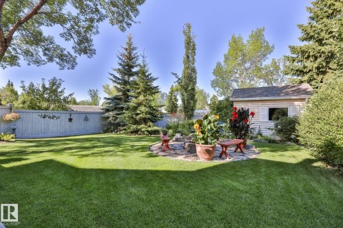 Expansive green lawn, mature trees, privacy fencing, stone patio area, and a detached storage shed - 3764 30 Street Nw, Edmonton, AB - Outdoor
