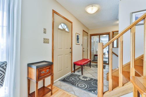 Front entry with a semicircular transom window, ceramic tile flooring and wood finished staircase - 3764 30 Street Nw, Edmonton, AB - Indoor Photo Showing Other Room