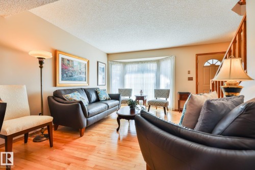 Birch Hardwood flooring throughout, bay window with quality sheer drapery, and a classic wood stair railing - 3764 30 Street Nw, Edmonton, AB - Indoor Photo Showing Living Room