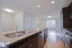 Kitchen island with a double stainless steel sink, granite countertop, and integrated dishwasher - 
