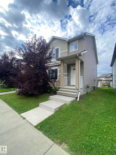 Two-story exterior with light-toned siding, concrete walkway, concrete porch steps, and a covered entry - 308 Watt Boulevard Sw, Edmonton, AB - Outdoor