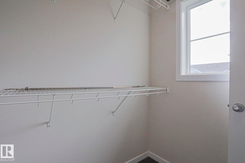 Built-in wire shelving, upper wire storage rack, bright window, and neutral wall tones - 308 Watt Boulevard Sw, Edmonton, AB - Indoor With Storage