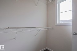 Built-in wire shelving, upper wire storage rack, bright window, and neutral wall tones - 