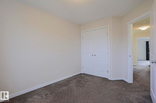 Neutral wall paint, built-in closet with panel doors, textured carpeting, and white trim - 308 Watt Boulevard Sw, Edmonton, AB - Indoor Photo Showing Other Room