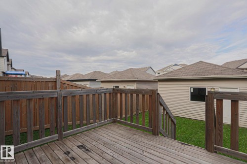 Wood deck with matching wood railings, leading to a fenced yard with green lawn - 308 Watt Boulevard Sw, Edmonton, AB - Outdoor With Exterior
