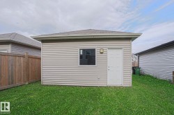Detached structure with horizontal siding, a single window, an exterior door, and an attached outdoor light fixture - 