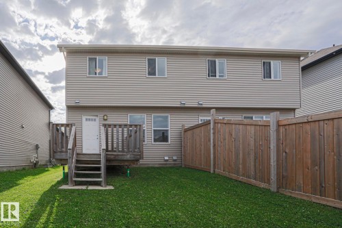 Two-story home with vinyl siding exterior, multiple windows across the upper level, and a spacious backyard featuring a manicured lawn - 308 Watt Boulevard Sw, Edmonton, AB - Outdoor With Exterior