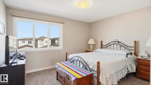 Carpeted room featuring light beige walls and a white textured ceiling - 731 36 Street Sw, Edmonton, AB - Indoor Photo Showing Bedroom