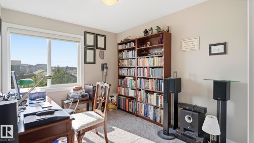 Bright room featuring a large window, neutral wall paint, and plush carpet flooring - 731 36 Street Sw, Edmonton, AB - Indoor Photo Showing Office
