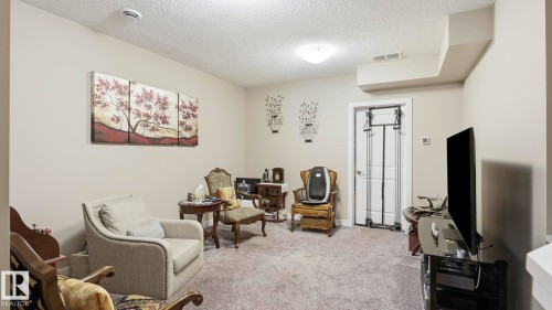 Carpeted room with neutral painted walls and a textured ceiling - 731 36 Street Sw, Edmonton, AB - Indoor