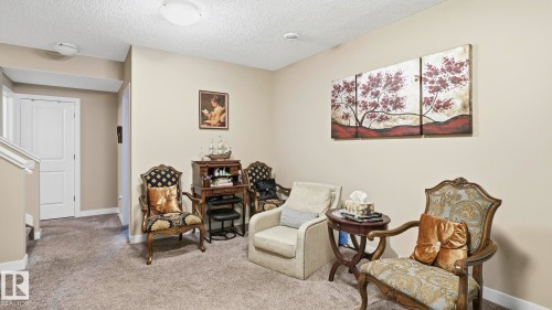 Carpeted landing with neutral wall paint and white baseboards - 731 36 Street Sw, Edmonton, AB - Indoor Photo Showing Other Room