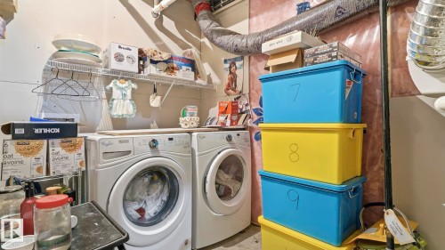 Laundry area featuring a front-loading washer and dryer, open wire shelving, and exposed ductwork - 731 36 Street Sw, Edmonton, AB - Indoor Photo Showing Laundry Room
