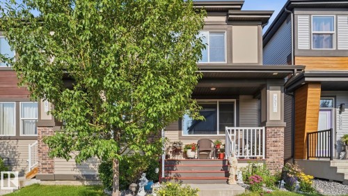 Contemporary two-story residence featuring a covered front porch with white railings, a brick and siding facade, and multiple windows - 731 36 Street Sw, Edmonton, AB - Outdoor With Deck Patio Veranda