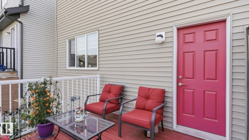 Exterior deck featuring a rich red-toned flooring and white railings - 731 36 Street Sw, Edmonton, AB - Outdoor With Deck Patio Veranda With Exterior
