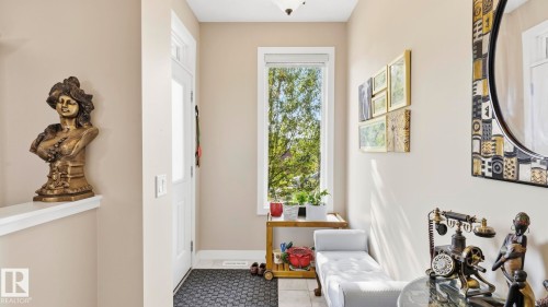 Entryway featuring a white paneled door with a transom window, a tall vertical window, neutral wall paint, and tile flooring - 731 36 Street Sw, Edmonton, AB - Indoor Photo Showing Other Room