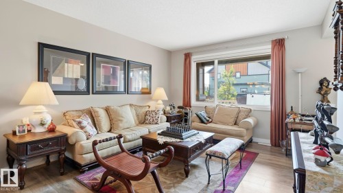 Living area featuring wood-finish flooring, a large window, and light-toned wall paint - 731 36 Street Sw, Edmonton, AB - Indoor Photo Showing Living Room