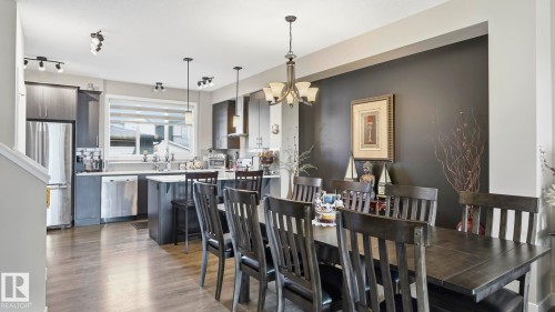 Open-concept dining area and kitchen featuring wood-finish flooring, recessed lighting, and a chandelier - 731 36 Street Sw, Edmonton, AB - Indoor Photo Showing Dining Room