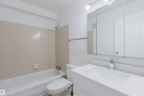 White vanity with an integrated sink and chrome faucet - #106 10520 80 Av Nw, Edmonton, AB - Indoor Photo Showing Bathroom