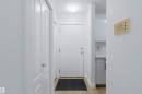 Light wood-finish flooring with white baseboards - #106 10520 80 Av Nw, Edmonton, AB  - Indoor Photo Showing Other Room 