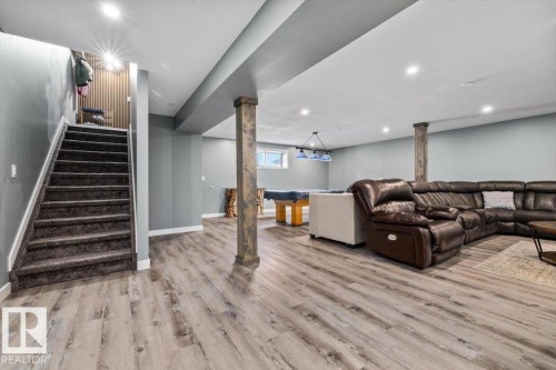 Finished lower level with recessed lighting, wood-finish flooring, and a carpeted staircase - 5203 23A Avenue Sw, Edmonton, AB - Indoor
