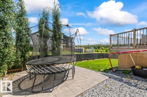 Expansive backyard featuring a paver patio, gravel landscaping, and a wooden deck with dark railings - 5203 23A Avenue Sw, Edmonton, AB - Outdoor With Deck Patio Veranda