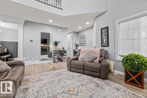 Wood-finish flooring, recessed lighting, and a large window with roller shades - 5203 23A Avenue Sw, Edmonton, AB - Indoor Photo Showing Living Room