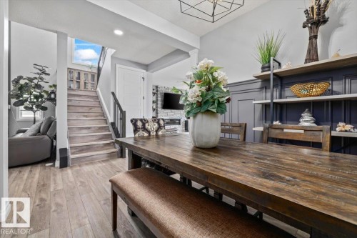 Wood-finish flooring throughout, with a paneled accent wall and built-in shelving - 5203 23A Avenue Sw, Edmonton, AB - Indoor