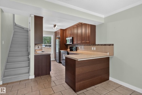 Kitchen with wood cabinetry, tiled flooring, and a breakfast bar - 11549 88 Street Nw, Edmonton, AB - Indoor Photo Showing Kitchen