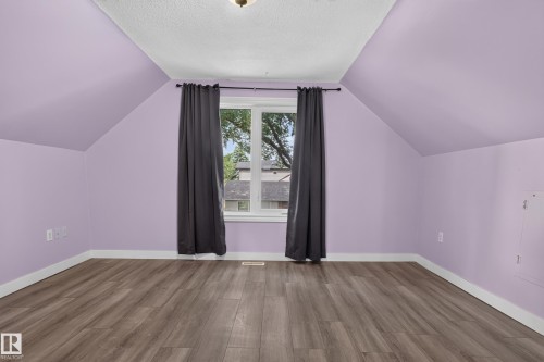 Room with angled ceilings, wood-finish flooring, and a double window with white trim - 11549 88 Street Nw, Edmonton, AB - Indoor Photo Showing Other Room