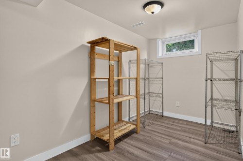 Wood-finish flooring, white trim, and a window with white casing - 11549 88 Street Nw, Edmonton, AB - Indoor Photo Showing Other Room