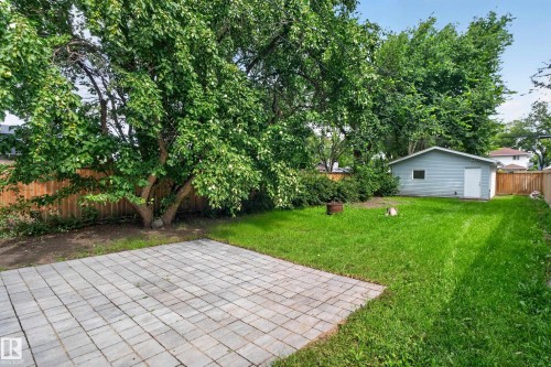 Expansive green lawn, paver patio, established trees, wood fence, and a detached structure - 11549 88 Street Nw, Edmonton, AB - Outdoor With Backyard
