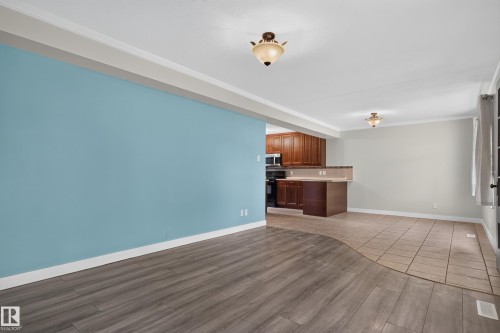 Wood-finish flooring, tiled flooring, wood cabinetry, built-in microwave, and ceiling-mounted light fixtures - 11549 88 Street Nw, Edmonton, AB - Indoor Photo Showing Kitchen