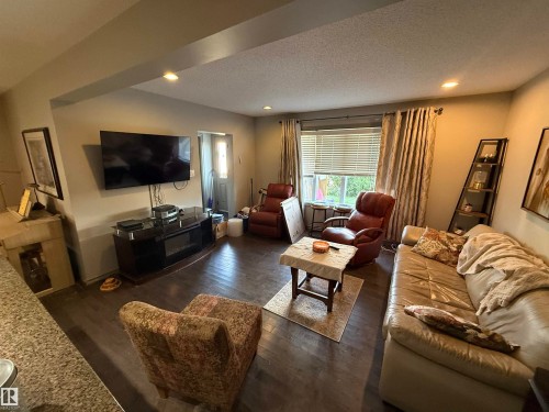 Recessed lighting illuminates wood-finish flooring throughout this living space - 7065 Cardinal Way Sw, Edmonton, AB - Indoor Photo Showing Living Room