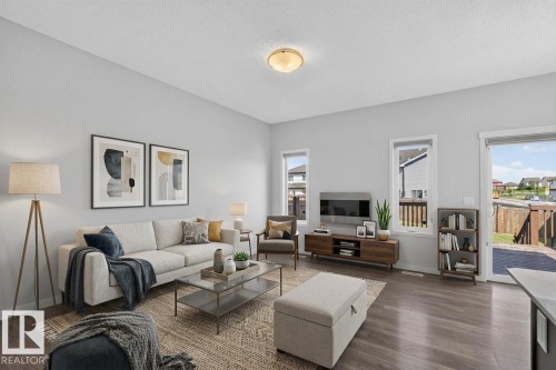 Wood-finish flooring, light gray walls, white trim, recessed lighting, and a glass-paneled door - 1404 25 Avenue Nw, Edmonton, AB - Indoor Photo Showing Living Room